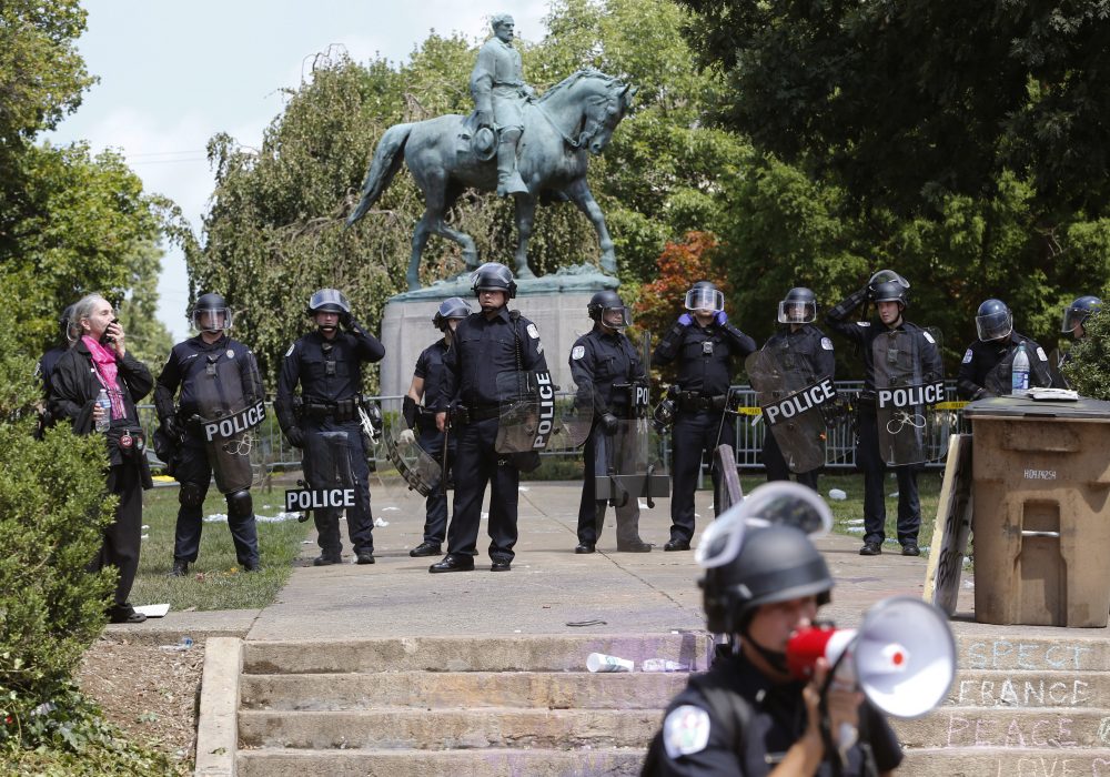 State Police in riot gear guard Lee Park after a white nationalist demonstration was declared illegal and the park was cleared in Charlottesville, Va., Saturday, Aug. 12, 2017. Hundreds of people chanted, threw punches, hurled water bottles and unleashed chemical sprays on each other Saturday after violence erupted at the white nationalist rally. (Steve Helber/AP)
