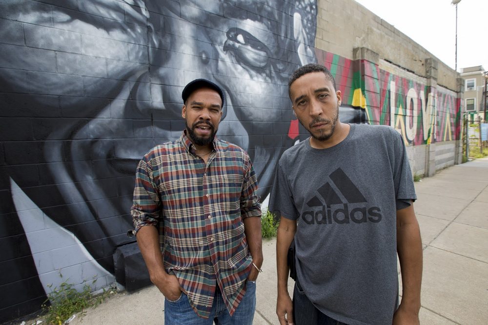 Artist Thomas &quot;Kwest&quot; Burns and activist Jamarhl Crawford stand in front of the &quot;Roxbury Love&quot; mural on Warren Street. (Jesse Costa/WBUR)