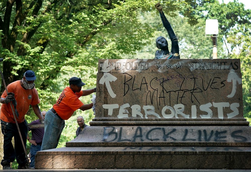 Baltimore city workers remove graffiti from the pedestal where a statue dedicated to Robert E. Lee and Thomas &quot;Stonewall&quot; Jackson stood Aug. 16, 2017 in Baltimore. The city removed four statues of Confederate heroes from city parks overnight, following the weekend's violence in Charlottesville, Va. (Win McNamee/Getty Images)