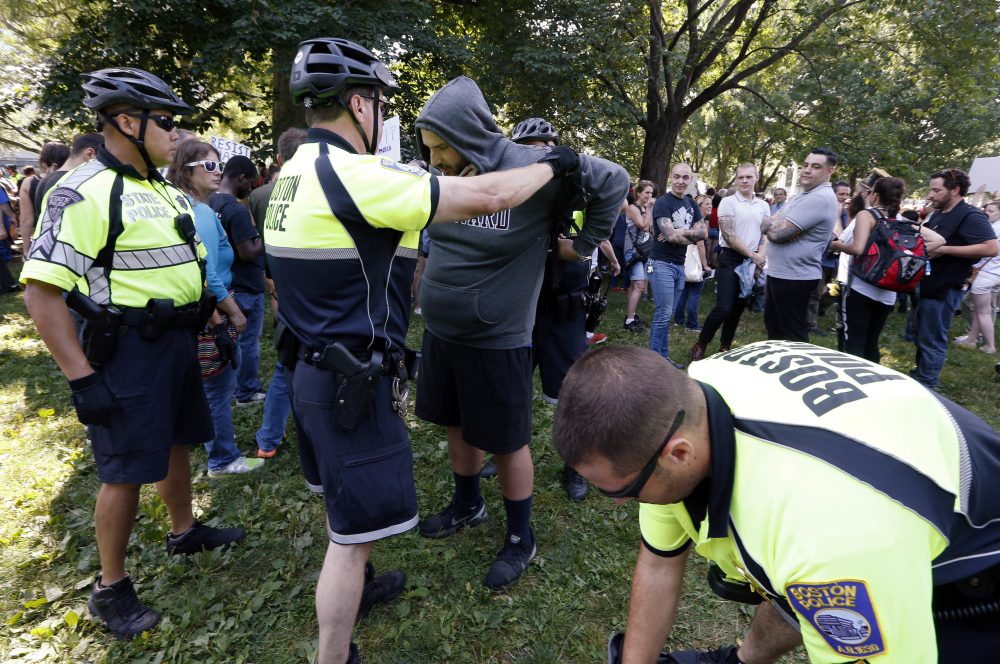 State and city police inspect people arriving on Boston Common. The permit for the rally came with severe restrictions, including a ban on backpacks, sticks and anything that could be used as a weapon. (Michael Dwyer/AP)