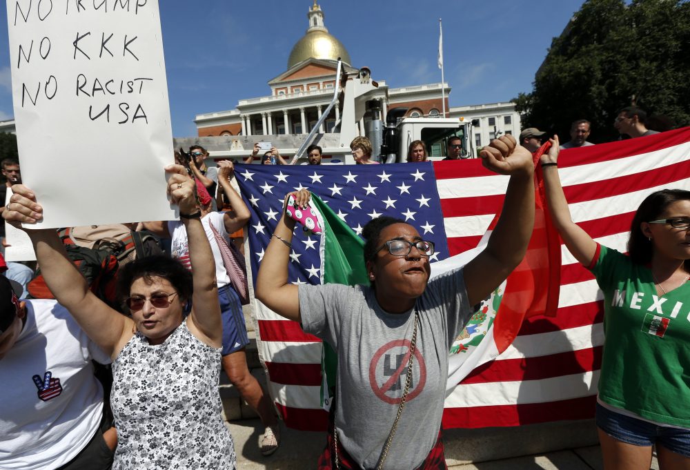 Counter-protesters hold signs and chant at the State House before the rally on Boston Common. (Michael Dwyer/AP)