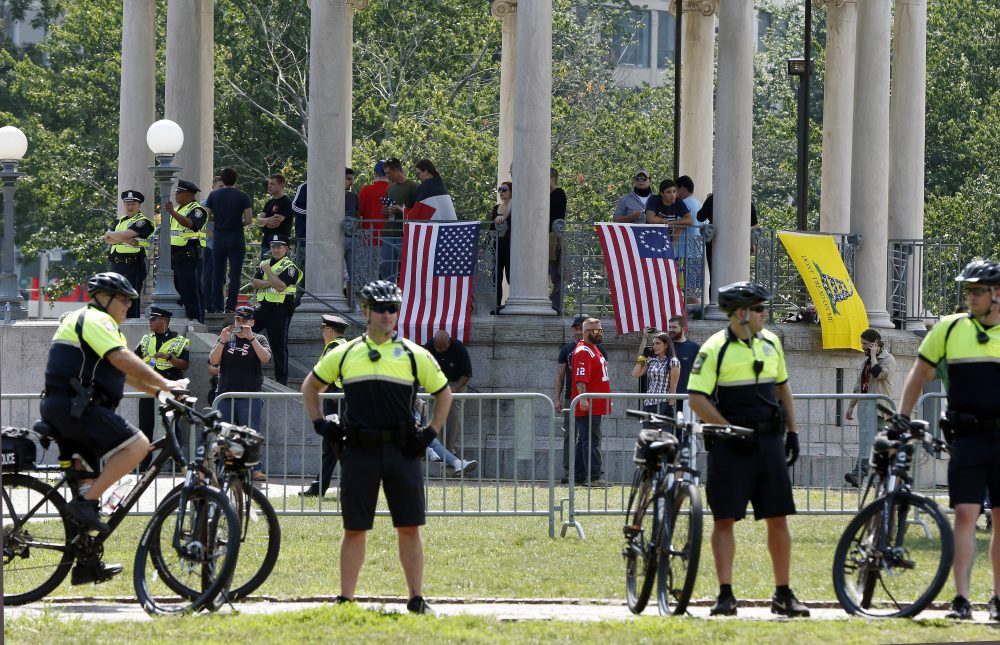 Police stand at a barricade around the Parkman Bandstand just before a planned, self-described free speech rally begins on Boston Common. Inside the barricade are supporters of the rally. Thousands of counter-protesters flocked to the Common to demonstrate, too. (Michael Dwyer/AP)