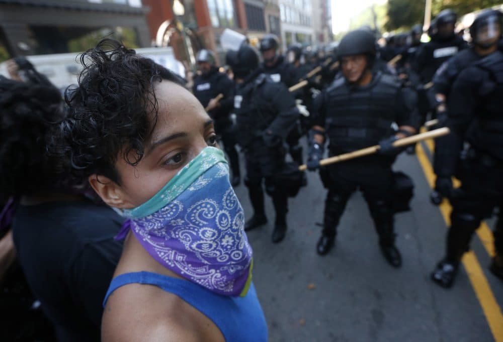A counter-protester stands in front of police near the rally. (Michael Dwyer/AP)