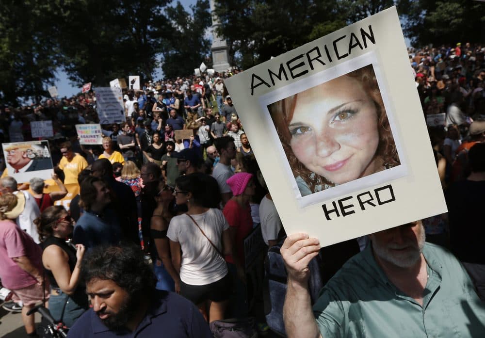 A counter-protester holds a photo of Heather Heyer on Boston Common. (Michael Dwyer/AP)