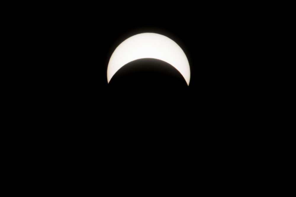 The partial solar eclipse is seen at it's peak in Boston at 2:46 p.m. (Jesse Costa/WBUR)