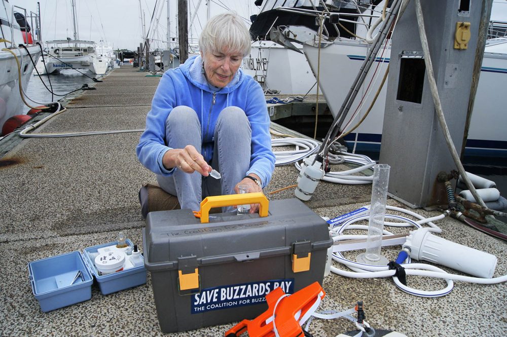 Chris Parks, a volunteers for the Buzzards Bay Coalition, test water conditions at Fairhaven Shipyard. (Lynn Jolicoeur/WBUR)