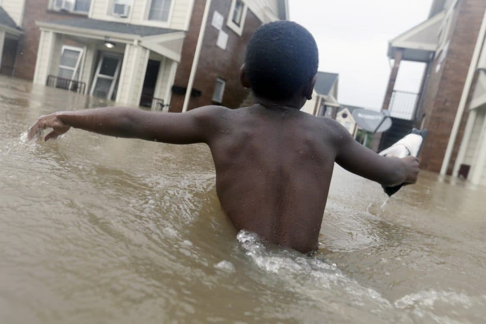 Jayveon Murphy, 10, makes is way through floodwaters from Tropical Storm Harvey to check on a neighbor at his apartment complex in Houston on Sunday. (LM Otero/AP)