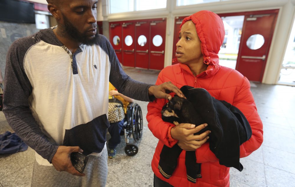 Brandon Spears, left, checks on his wife D&#039;Ona Spears and her dog, Missy, at a shelter for flood evacuees in the convention center in Houston. Spears and her family walked to the shelter after her home was flooded with water from the Buffalo Bayou. (LM Otero/AP)