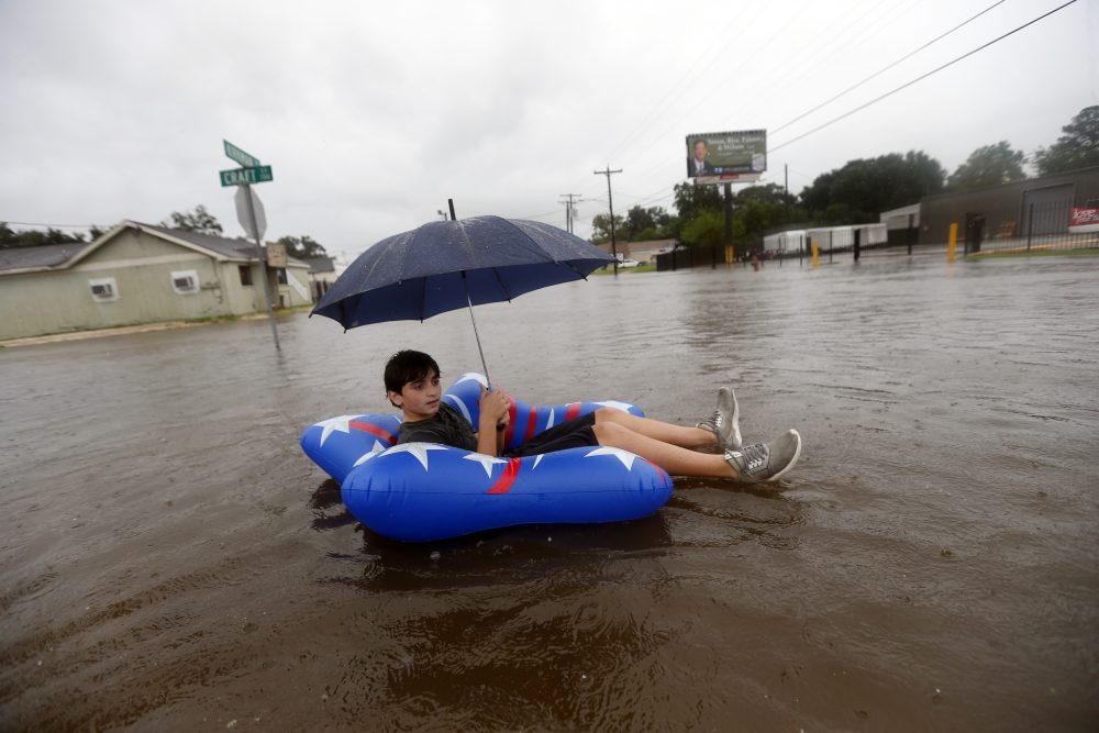 Julius Verret, 14, floats in street flooding in Lake Charles, La., as the city is receiving heavy rains from Tropical Storm Harvey on Sunday. The storm came ashore on the Texas Gulf Coast as a category four hurricane. (Gerald Herbert/AP)