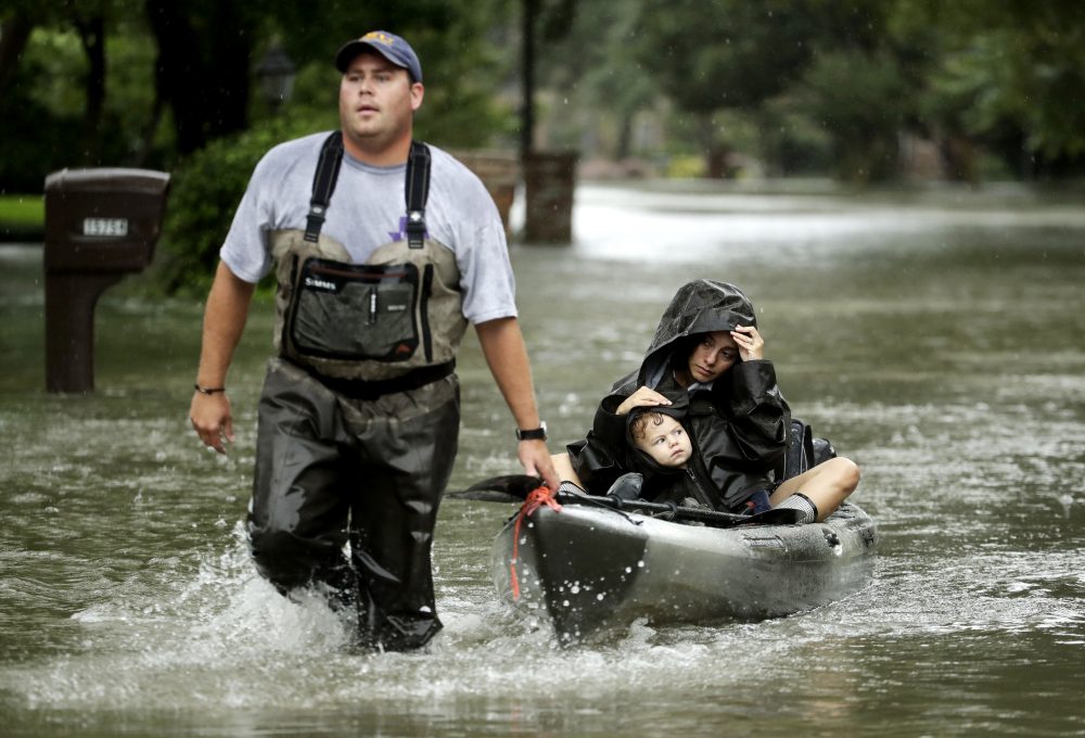People evacuate a neighborhood inundated by floodwaters from Harvey in Houston. (AP Photo/Charlie Riedel)