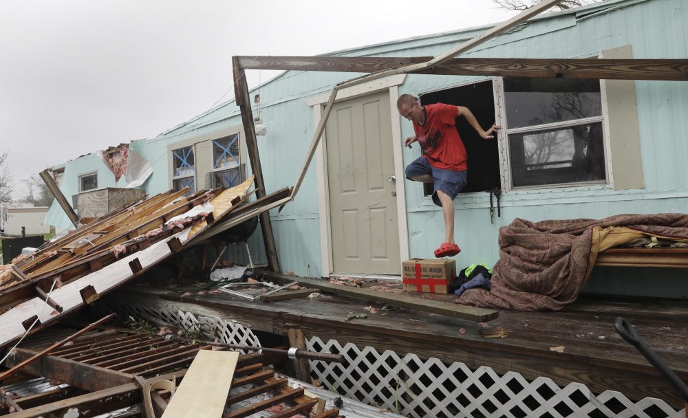 Sam Speights exits a window of his home that was destroyed in the wake of Harvey on Monday in Rockport, Texas. (Eric Gay/AP)