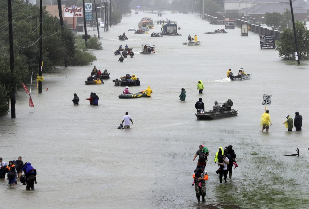 Rescue boats fill a flooded street as flood victims are evacuated in Houston on Monday. (David J. Phillip/AP)