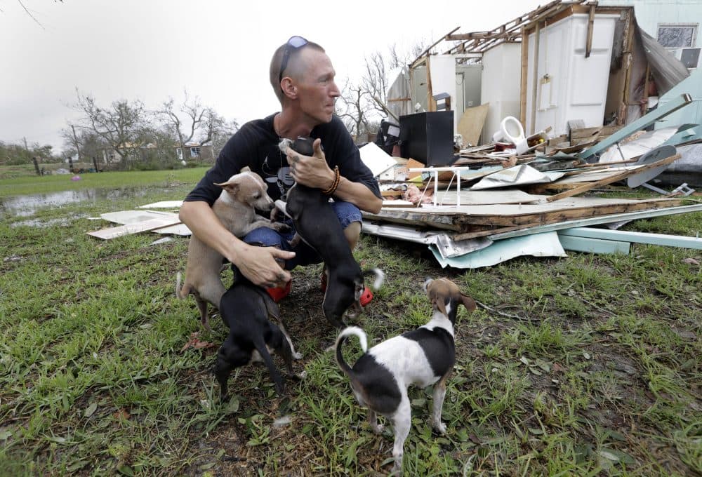 Sam Speights tries to hold back tears while holding his dogs and surveying the damage to his home in the wake of Hurricane Harvey on Sunday in Rockport, Texas. Speights tried to stay in his home during the storm but had to move to other shelter after his home lost its roof and back wall. (Eric Gay/AP)