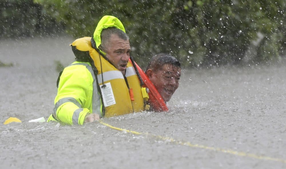 Wilford Martinez, right, is rescued from his flooded car by Harris County Sheriff's Department Richard Wagner along Interstate 610. (David J. Phillip/AP)