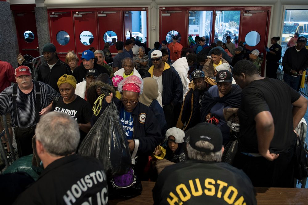 People wait to be checked by police before entering a shelter in the George R. Brown Convention Center during the aftermath of Hurricane Harvey on Aug. 28, 2017 in Houston, Texas. (Brendan Smialowski/AFP/Getty Images)