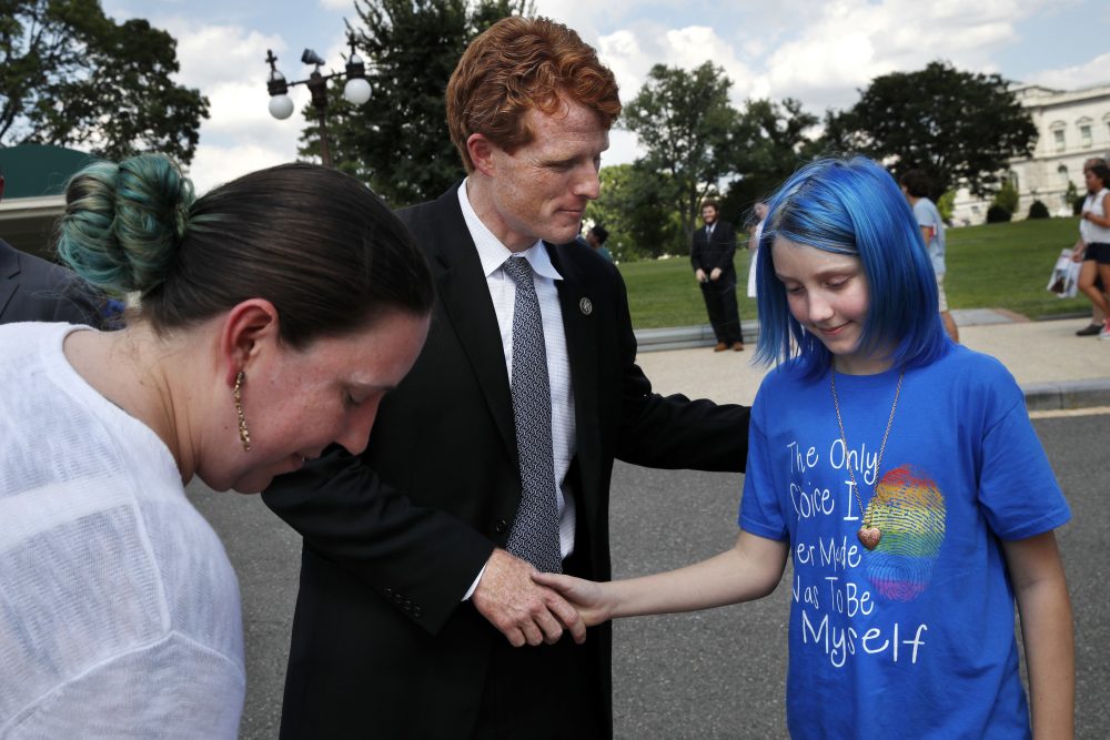 Rep. Joe Kennedy, D-Mass., center, shakes hands with an 11-year-old transgender girl who goes by the name Blue, whose parent is an airman at Ramstein Air Base, after Blue and her mother Jess Girven, left, attended Kennedy's event in support of transgender members of the military on July 26 on Capitol Hill. (Jacquelyn Martin/AP)