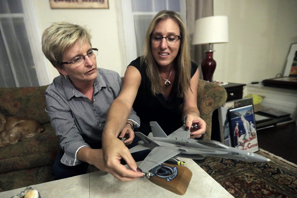 Alaina Kupec, right, and her wife Kathy Brennan work a model F18 jet in the home they just moved in to, on July 26 in Orange, N.J. Kupec, a transgender woman who worked with pilots who flew F18 jets while serving as a Navy intelligence officer from 1992 until 1995, said she felt "heartbreak" after she heard about Trump's pronouncement banning transgender people from military service. The 48-year-old publicly transitioned to life as a woman in 2013. (Julio Cortez/AP)