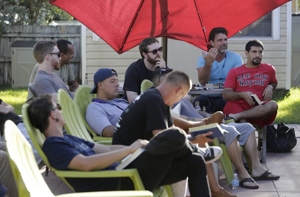 In this July 6 photo, Timothy Schnellenberger, rear right, speaks with recovering addicts at his substance abuse treatment center, Recovery Boot Camp, in Delray Beach, Fla. Schnellenberger has operated treatment centers since 2002, and says that the influx of criminal operators has cast a dark shadow over an industry with deep roots in South Florida. (Lynne Sladky/AP)