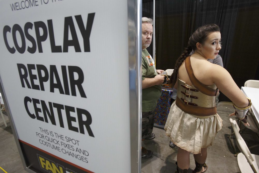 Morgan Prittie, right, of Derry, N.H., adjusts her costume in a booth at Boston Comic Con, Friday, Aug. 11, 2017, in Boston. The convention is being held at the Boston Convention &amp; Exhibition Center through Sunday. (AP Photo/Michael Dwyer)