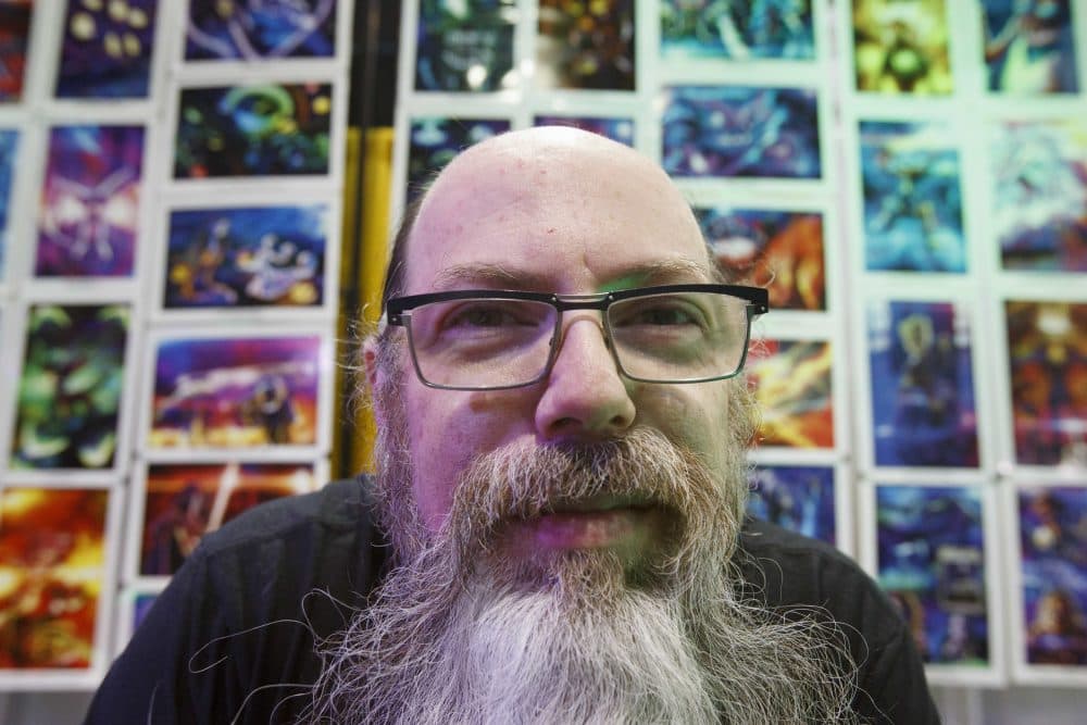 Artist Jerry Pesce poses in front of a wall of his art in his booth at Boston Comic Con, Friday, Aug. 11, 2017, in Boston. The convention is being held at the Boston Convention &amp; Exhibition Center through Sunday. (AP Photo/Michael Dwyer)