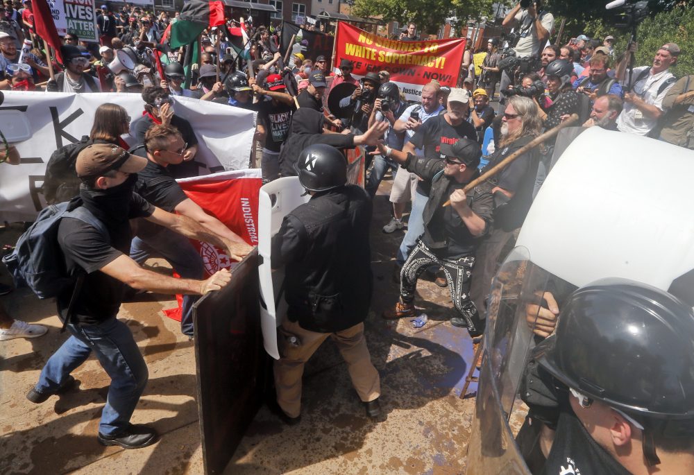 White nationalist demonstrators clash with counter demonstrators at the entrance to Lee Park in Charlottesville, Va., Saturday, Aug. 12, 2017. Gov. Terry McAuliffe declared a state of emergency and police dressed in riot gear ordered people to disperse after chaotic violent clashes between white nationalists and counter protestors. (AP Photo/Steve Helber)
