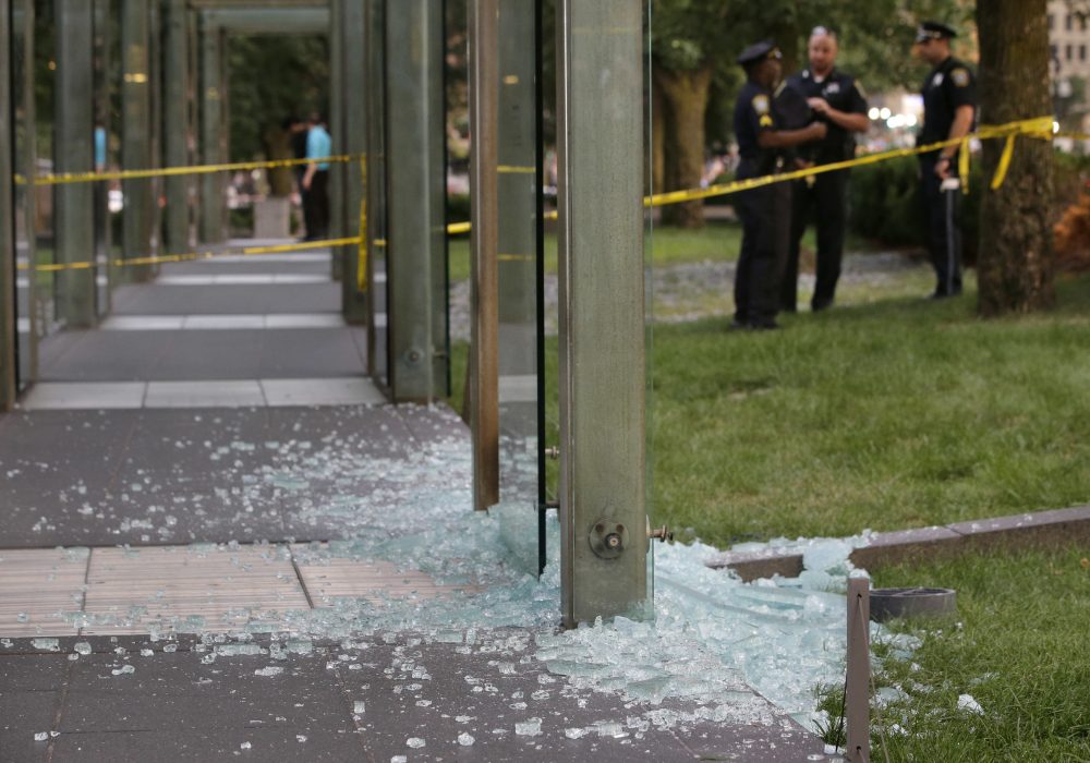 In this file photo, law enforcement officials stand near broken glass at the New England Holocaust Memorial in Boston in August 2017. Gov. Charlie Baker has announced the revival of a hate crime task force after a report showed an increase in hate crimes from 2016 to 2017. (Steven Senne/File/AP)