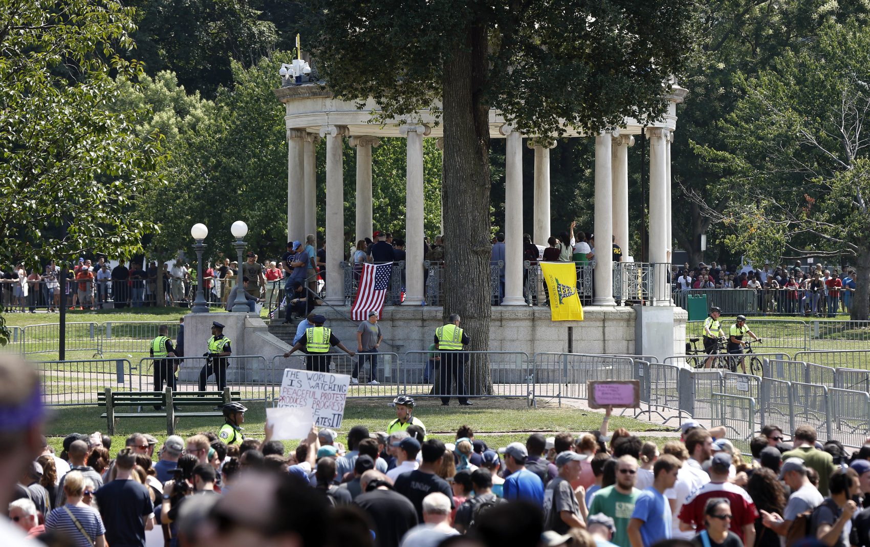Organizers stand on the bandstand on Boston Common during a self-described free speech rally staged on Saturday in Boston. Counter-protesters stand along barricades ringing the bandstand. (Michael Dwyer/AP)