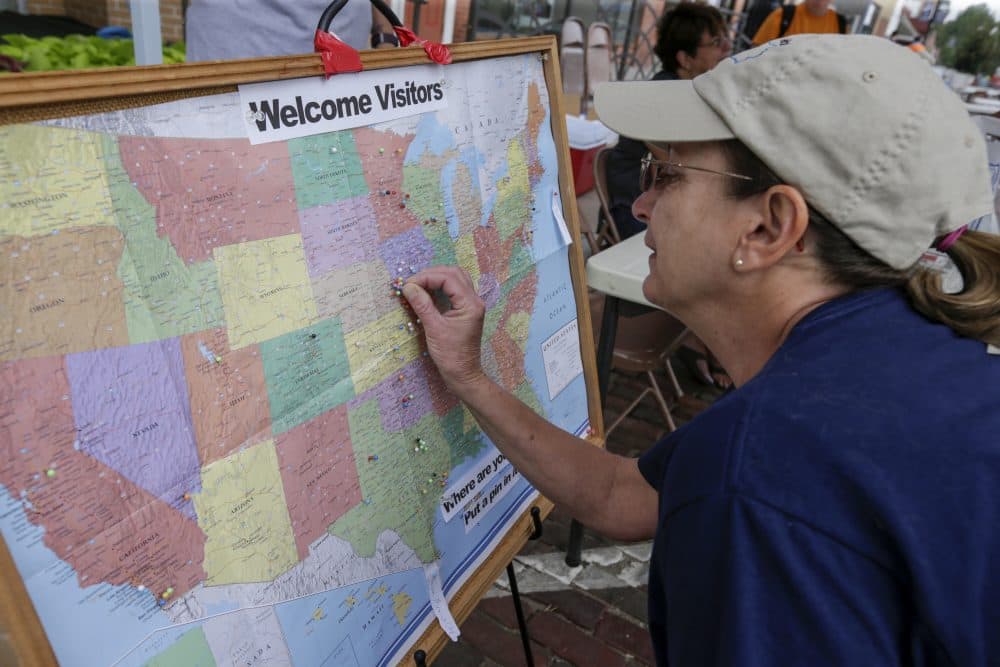 Cindy Gottlieb, of Missouri Valley, Iowa, adds a pin on the map that shows where visitors to Falls City, Nebraska, came from to view the eclipse. (Nati Harnik/AP)