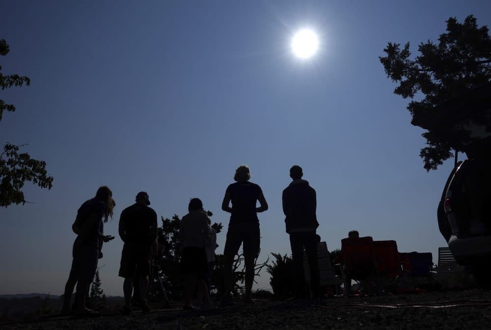 People gather near Redmond, Ore., to view the sun as it nears a total eclipse. (Ted S. Warren/AP)