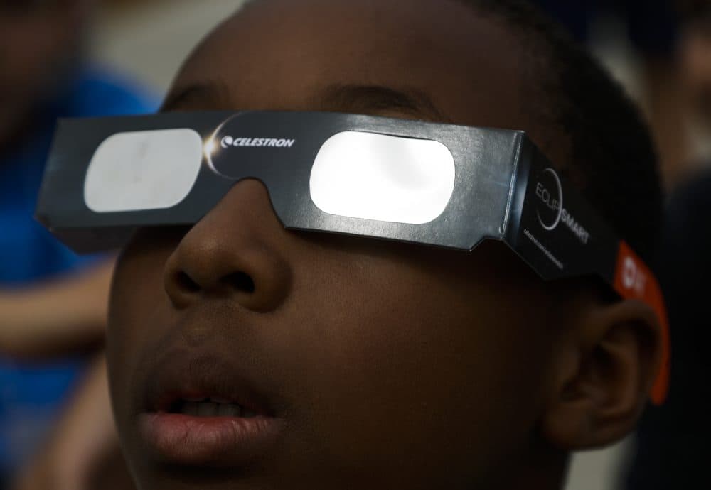 Josh Mims, 9, watches as the moon passes in front of the sun during a partial solar eclipse in Milwaukee. (Morry Gash/AP)