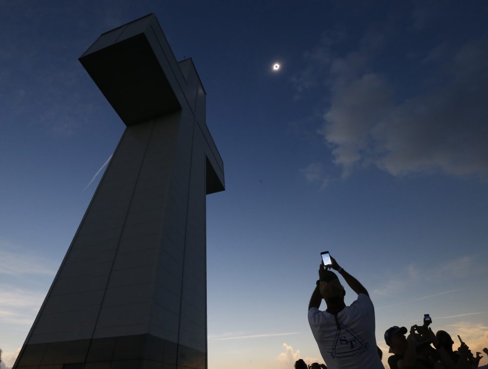 A total solar eclipse is seen above the Bald Knob Cross of Peace Monday in Alto Pass, Ill. More than 700 people visited the over 100 foot cross for the event. (Charles Rex Arbogast/AP)