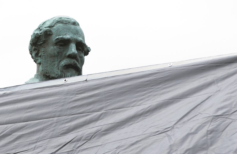 City workers drape a tarp over the statue of Confederate General Robert E. Lee in Emancipation park in Charlottesville, Va., on Aug. 23, 2017. (Steve Helber/AP)