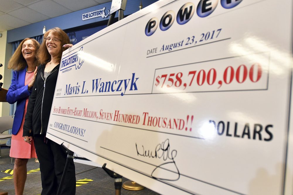 Mavis Wanczyk, of Chicopee, Mass., stands by a poster of her winnings during a news conference where she claimed the $758.7 million Powerball prize at Massachusetts State Lottery headquarters, Thursday, Aug. 24, 2017, in Braintree, Mass. Officials said it is the largest single-ticket Powerball prize in U.S. history. At left is state treasurer Deb Goldberg. (Steven Senne/ AP)