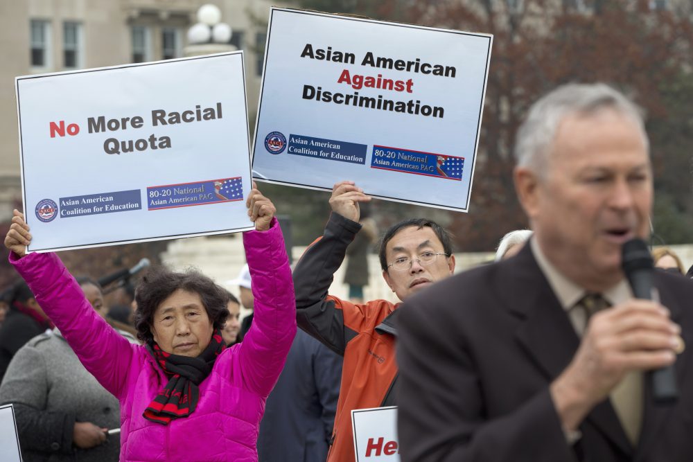 Guixue Zhou of North Potomac, Md., left, and Samuel Yan, of Loudoun County, Va., protest against racial quotas during a rally outside the Supreme Court in Washington, Wednesday, Dec. 9, 2015, as the court hears oral arguments in the Fisher v. University of Texas at Austin affirmative action case. At right is Rep. Dana Rohrabacher, R-Calif., speaking in solidarity with the Asian American Coalition for Education protest. (Jacquelyn Martin/AP)