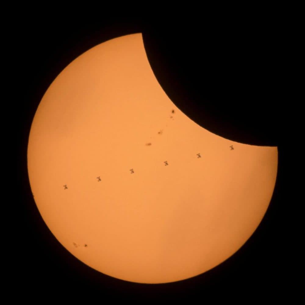 Made from seven frames, this image of the solar eclipse near Banner, Wyoming, shows the International Space Station as it transits by the sun. (NASA)