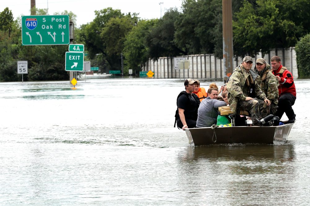 Residents are rescued from their homes surrounded by floodwaters. (David J. Phillip/AP)