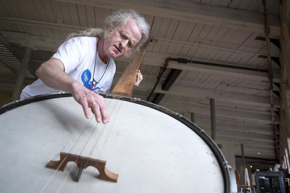 Musician Mark Stewart plays a giant banjo created by Gunnar Schonbeck at MASS MoCA. (Robin Lubbock/WBUR)