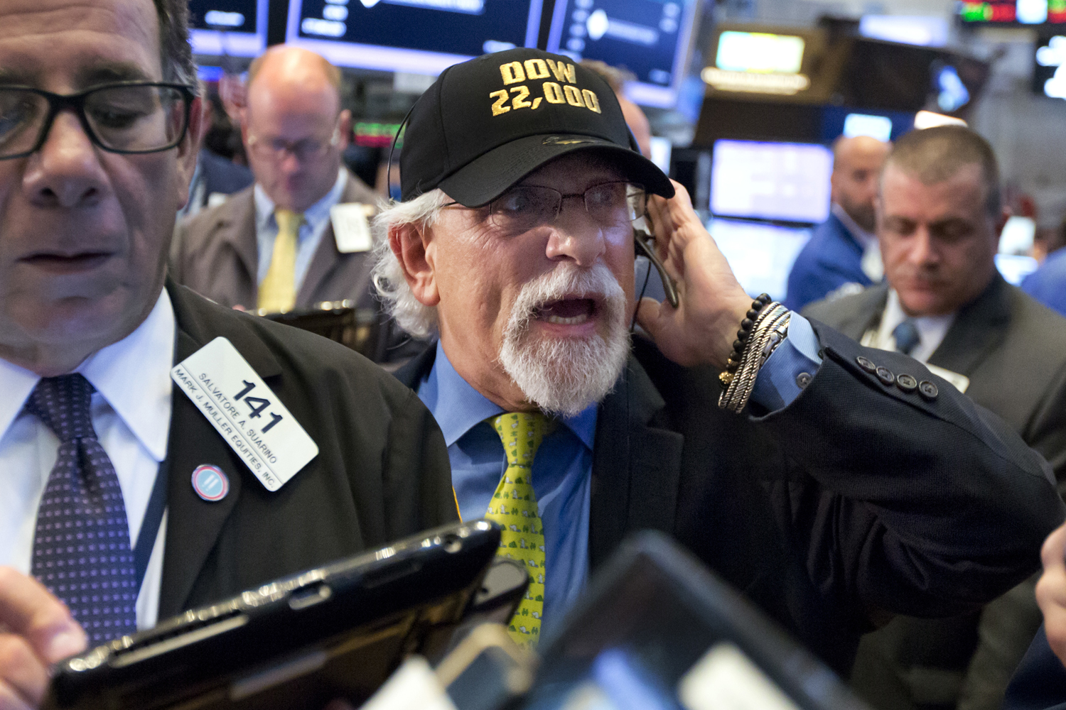 Trader Peter Tuchman, center, wears a "Dow 22,000" hat as he works on the floor of the New York Stock Exchange, Wednesday, Aug. 2, 2017. (Richard Drew/AP)