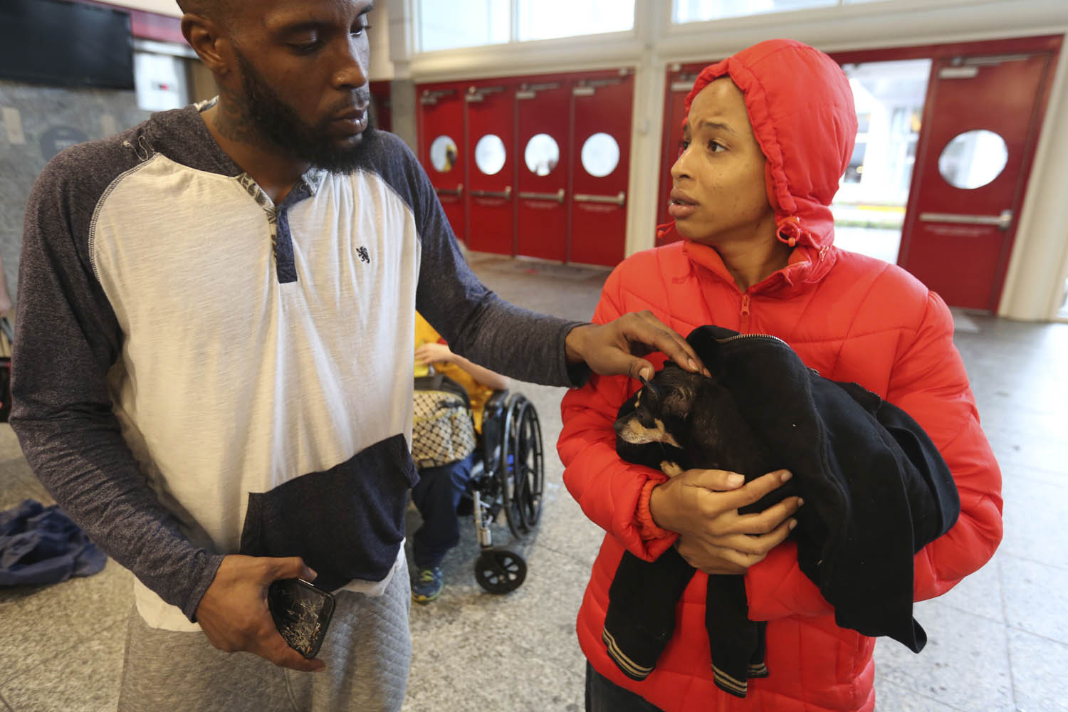 Brandon Spears, left, checks on his wife D'Ona Spears and her dog Missy at a shelter for flood evacuees in the convention center in downtown Houston, Texas. Spears and her family walked to the shelter after her home was flooded with water from the Buffalo Bayou. (LM Otero/AP)