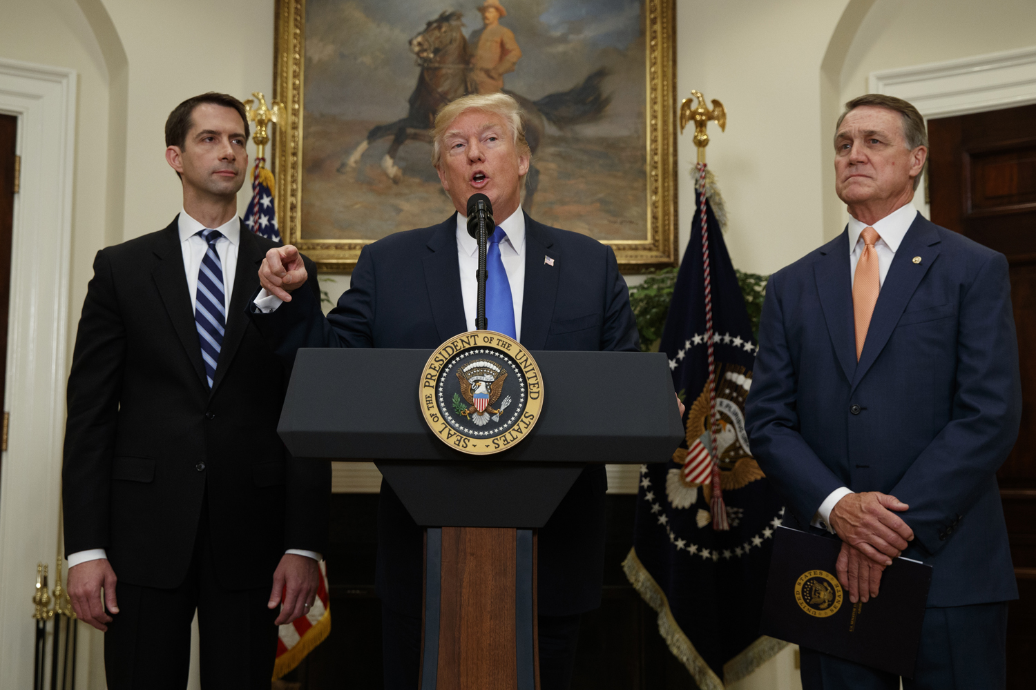 President Donald Trump, flanked by Sen. Tom Cotton, R- Ark., left, and Sen. David Perdue, R-Ga., speaks in the White House in Washington, Wednesday, Aug. 2, 2017, during the unveiling of legislation that would place new limits on legal immigration. (Evan Vucci/AP)
