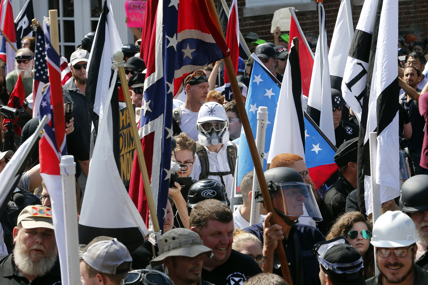 White nationalist demonstrators walk into the entrance of Lee Park surrounded by counter demonstrators in Charlottesville, Va., Saturday, Aug. 12, 2017. (Steve Helber/AP)