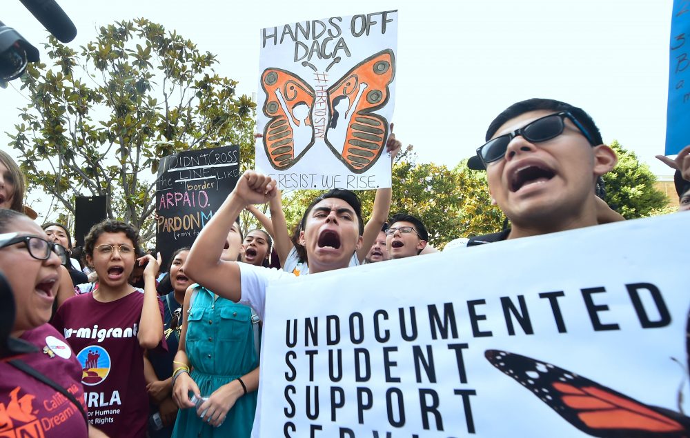 Young immigrants and supporters walk holding signs during a rally in support of Deferred Action for Childhood Arrivals (DACA) in Los Angeles, Calif. on Sept. 1, 2017. (Frederic J. Brown/AFP/Getty Images)