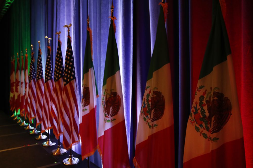 The national flags of Canada, the U.S. and Mexico are lit by stage lights before a news conference, at the start of the North American Free Trade Agreement renegotiations in Washington on Aug. 16, 2017. (Jacquelyn Martin/AP)