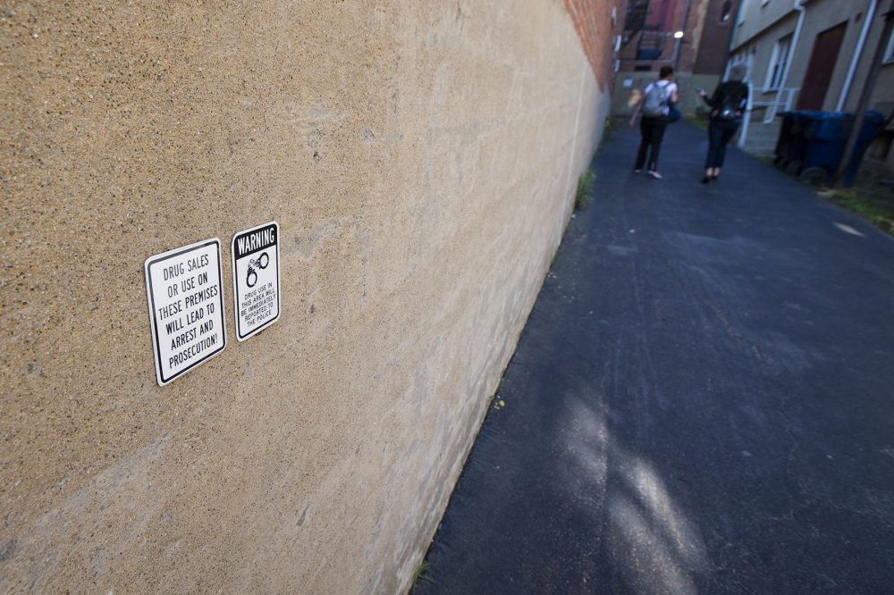 In an alley outside of Cambridge's Central Square, WBUR reporter Martha Bebinger, right, walks with Kristin, a drug user who has been repeatedly sexually assaulted while high. (Jesse Costa/WBUR)