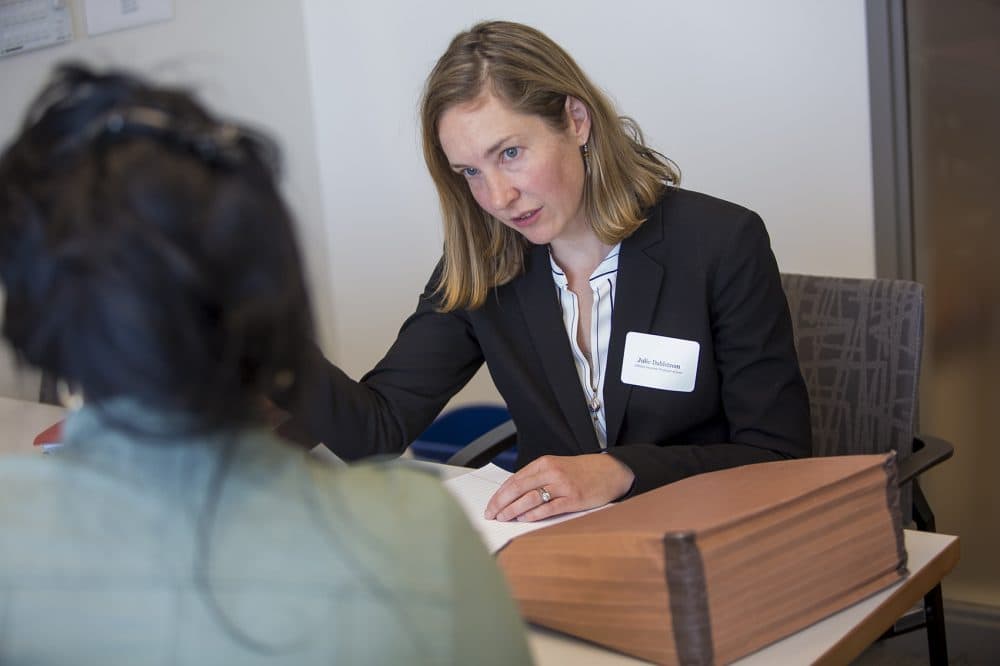 Julie Dahlstrom, director of Boston University's Immigrants’ Rights & Human Trafficking Program, consults with a client who is awaiting an answer about the U visa she applied for two years ago. (Jesse Costa/WBUR)