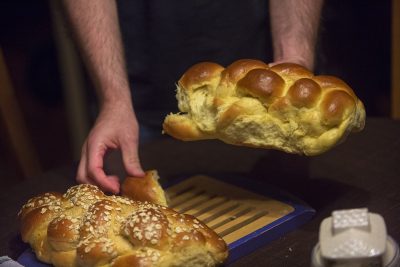 The breaking of the Challah bread before dinner at Susie and Rob's house. (Jesse Costa/WBUR)