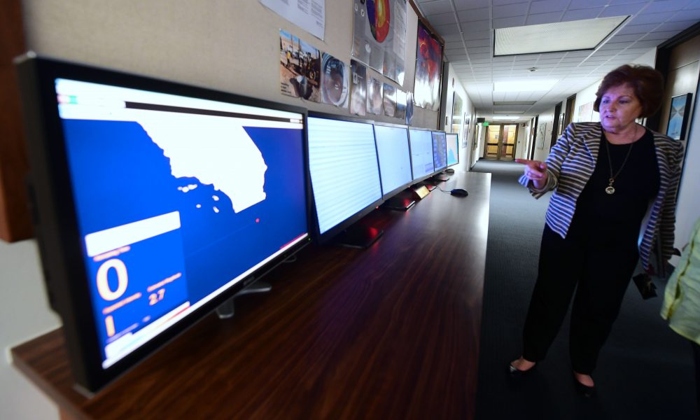 Margaret Vinci, manager at the Seismological Laboratory at Caltech, gestures toward a row of ShakeAlert user display screens monitoring California quake activity in Pasadena, Calif., on June 1, 2017. (Frederic J. Brown/AFP/Getty Images)