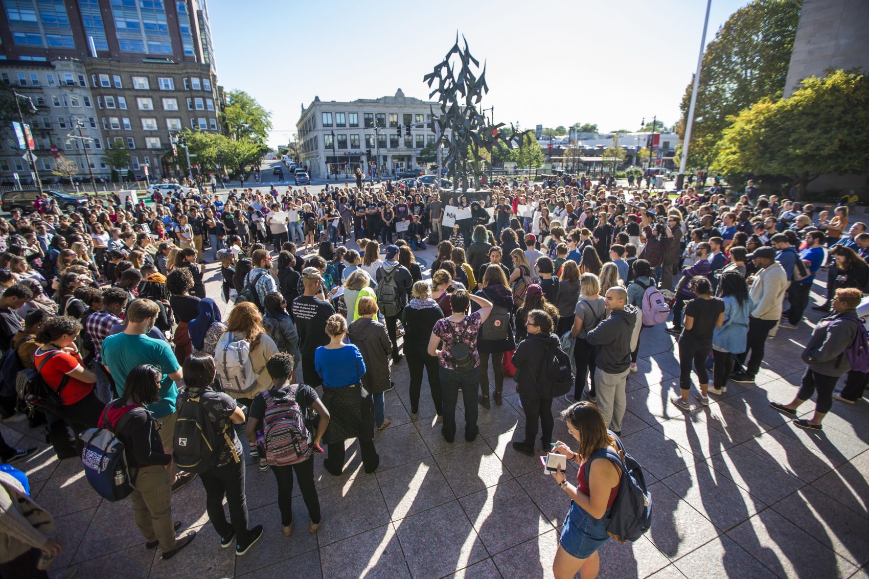 Black Lives Matter protesters gather in October 2016 in Boston University's Marsh Plaza. In the center is the sculpture, "Free At Last," that honors MLK's legacy. (Jesse Costa/WBUR)
