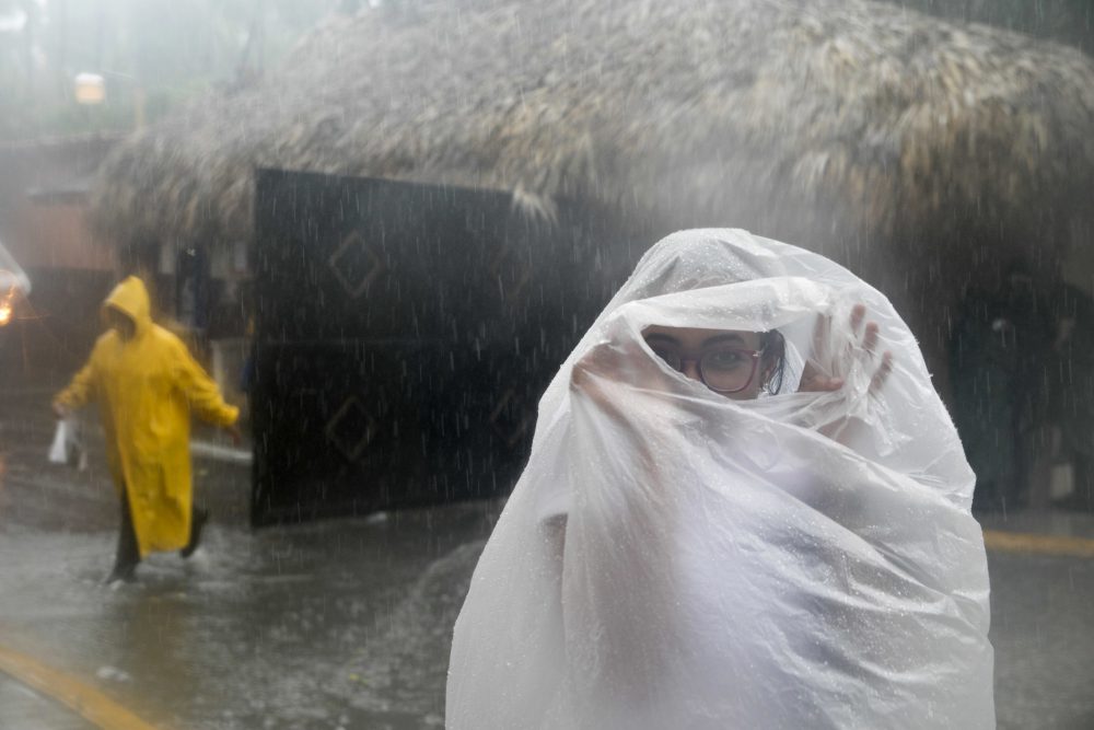 A woman covers herself with a plastic bag as she makes her way to work as the hurricane approaches the coast of Bavaro, Dominican Republic on Wednesday. (Tatiana Fernandez/AP)