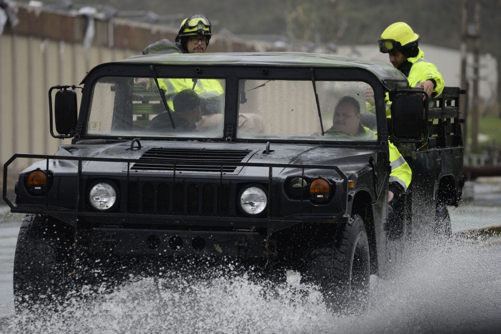 Rescue personnel from the Emergency Management Agency drive through a flooded road after the hurricane hit in Humacao, Puerto Rico on Tuesday. The hurricane could plunge the U.S. territory deeper into financial crisis. (Carlos Giusti/AP)